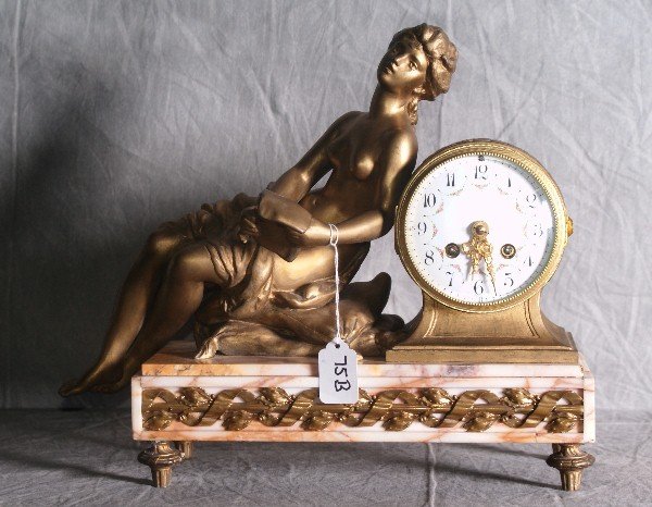 19th c dore bronze and marble figural clock with a nud: 19th c dore bronze and marble figural clock with a nude woman on pillows reading a scroll with a painted porcelain face and oroginal key, foundry marked on back lower section of clock in the manner of