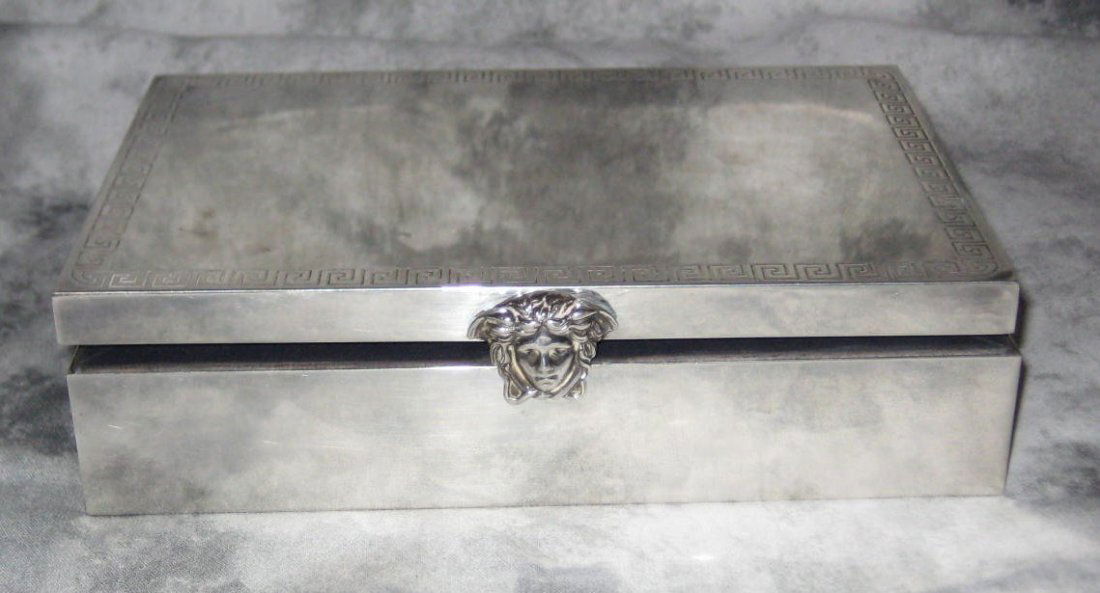 Versace sterling silver box with engraved Greek key: Versace sterling silver box with engraved Greek key design and head of Medusa mask, interior with Versace fabric. H: 1 7/8" W: 7 1/4" D: 4 7/8"