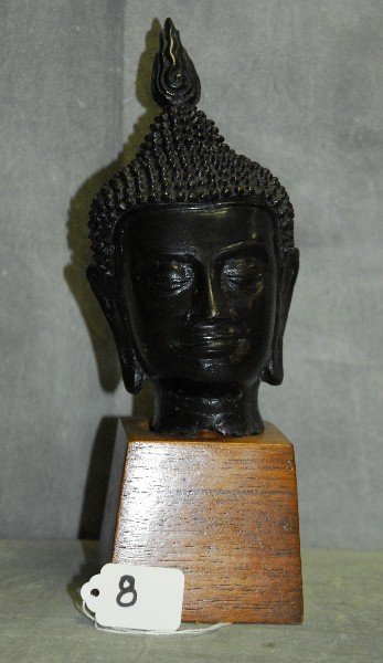 Bronze bust of a Buddha on a wood stand. H:11": Bronze bust of a Buddha on a wood stand. H:11"