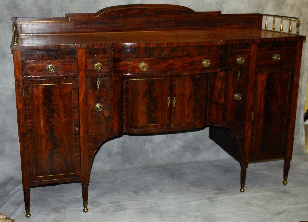 Tall American Federal Period Flame Mahogany Sideboard,: Tall American Federal Period Flame Mahogany Sideboard, Having a shaped back splash and brass gallery rail above a shaped rectangular top over an arrangemant of 5 drawers above a central pair of cupboa