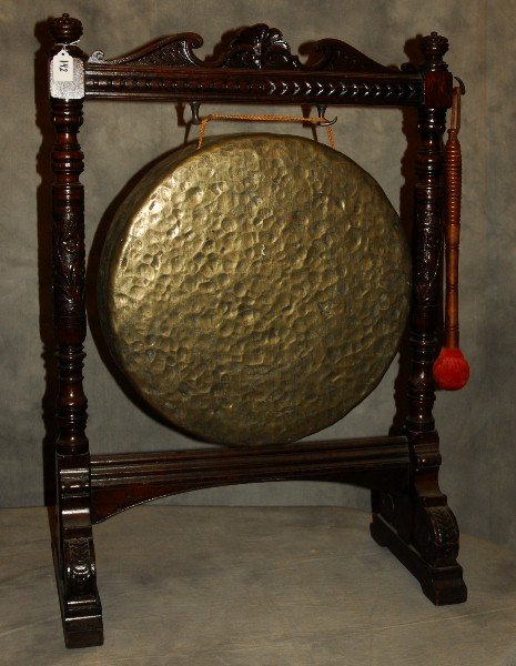 Chinese bronze gong in carved hardwood stand. H: 36" W:: Chinese bronze gong in carved hardwood stand. H: 36" W: 26" D: 12"