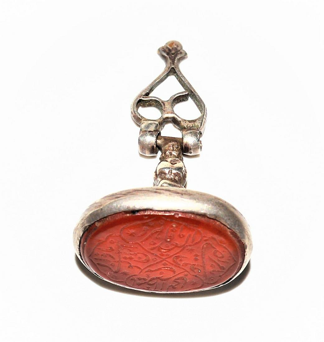 ISLAMIC PERSIAN/INDIAN FAUX CARNELIAN SILVER SEAL STAMP: A RARE ANTIQUE ISLAMIC PERSIAN/INDIAN ENGRAVED FAUX CARNELIAN ( NOT A STONE ) SILVER SEAL STAMP,PERSIA OR INDIA CIRCA 19TH CENTURY. Very Finely Insribed.The seal shaped like a lotus blossom engraved w