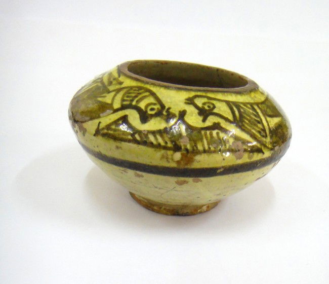 AN NISHAPUR GLAZED VASE EAST IRAN 12TH CENTURY: A FINE NISHAPUR YELLOWISH VASE ON CREAMY GROUND MOUTH WITH A CIRCULE BLACK LINE , PAINTED TWO BIRDS BOTH SIDE JOIN EACH OTHER HEAD TO HEAD .INTERIOR GLAZED . MEAURMENT : 7 cm high