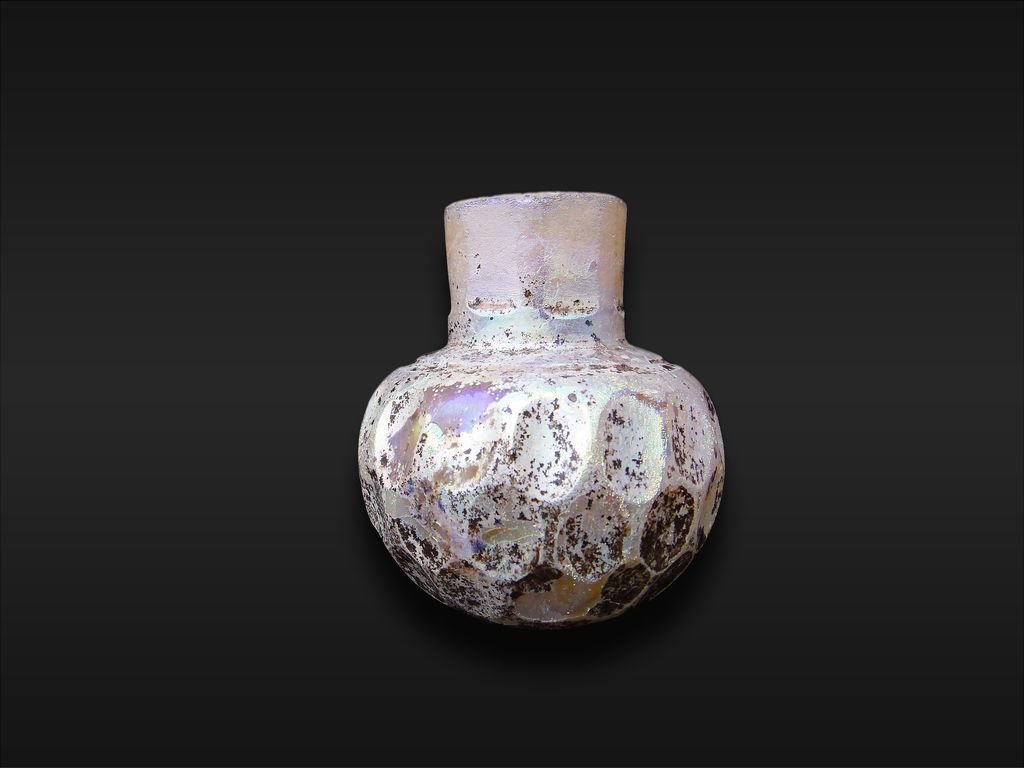 A Rare Wheel-Cut Clear Glass Bottle 9th Century: A Highly Important Islamic Wheel-Cut Clear Glass Bottle , Iran or Central Asia 9th Century , With spherical body and slightly flaring faceted neck, the body with a band of two rows of wheel-cut rounde