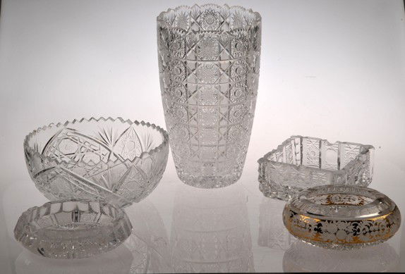 Five glass decorative objects, different shapes and siz: Cinco piezas de cristal.a) Florero. Diseño cortado. Decoración con motivos geométricos. Borde dentado. Altura: 26 cm.b) Centro de mesa. Diseño cortado. Decoración con motivos geométricos. Borde