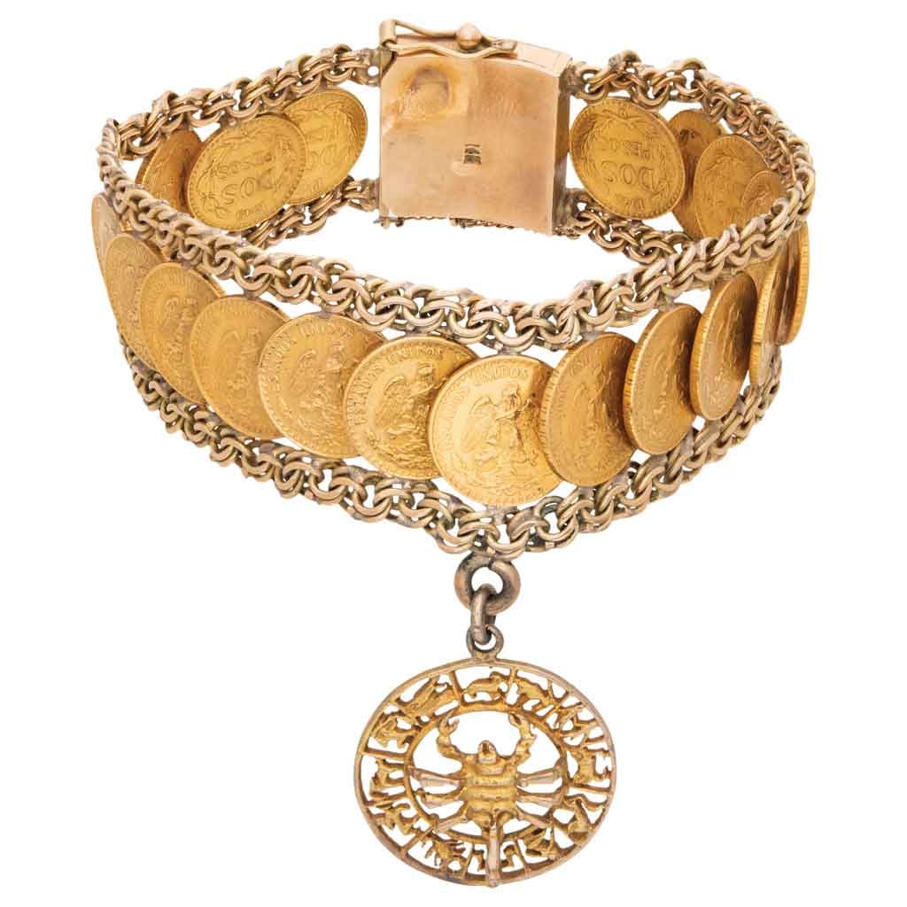 PULSERA CON MONEDAS EN ORO AMARILLO DE 10K Y 21.6K En oro de 10K. Broche de caja con seguro ocho y: PULSERA CON MONEDAS EN ORO AMARILLO DE 10K Y 21.6KEn oro de 10K. Broche de caja con seguro ocho y cadena de seguridad. Peso: 61.4 g. Largo: 18.0 cm aprox.Veinte monedas de dos pesos Oro Nacional acuñ