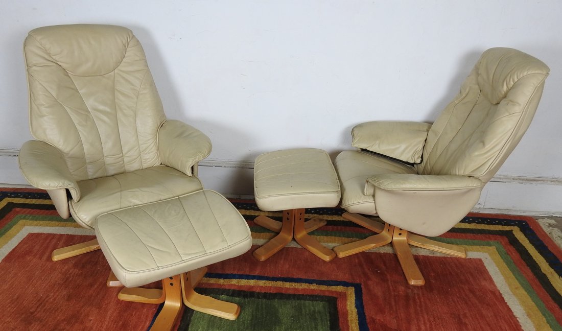 Pr. of Lounge Chairs and Ottomans: Beige leather reclining chairs each with an ottoman. Wear to the leather. 41"H X 33"W X 32 "D. Reclines to 44". 16"H X 21"W X 16 3/4"D.