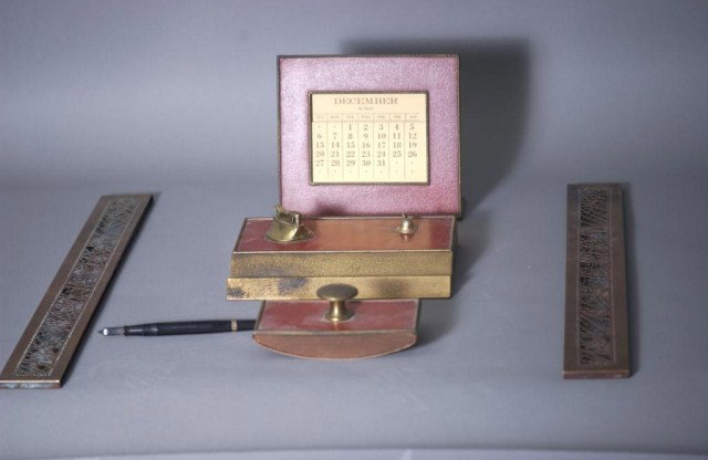 5 PC. Bronze Desk Ensemble: 5 PC. Bronze Desk Ensemble, 1-pair of Tiffany blotter ends, 1-Silver Crest Co. calendar, 1-pen holder and lighter combination (pen holder tip missing), 1-ink pad blotter.