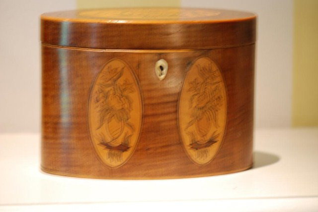 ANTIQUE ENGLISH INLAID TEA CADDY: Antique English Inlaid Tea Caddy, 19th century, oval, tiger maple veneer with oval exotic wood floral inlays and ivory key escutcheon, purchased at M. Turpin Antiques in London, England, in good condi