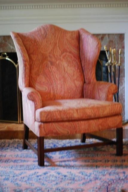 KITTINGER WING CHAIR: Kittinger Williamsburg Collection Wing Chair, multi-colored paisley tie-dyed fabric, exposed mahogany frame, in good condition, 45" high x 34" wide x 21" seat depth.