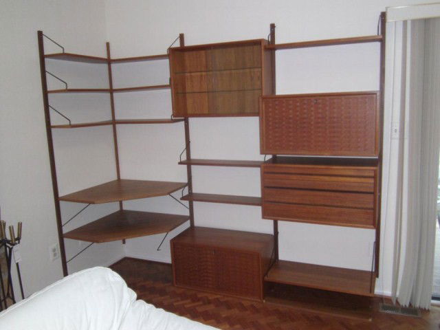 DANISH & ROYAL SYSTEM/CADO WALL UNIT: Multi-piece teak suspended wall unit with corner shelves, sliding glass door curio, drop front bar, drop front desk, and 3 drawer storage sections. In good condition.