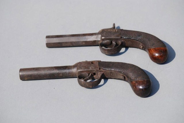 2 ANTIQUE DUELING PISTOLS: 7-1/4" long with wooden handles. Simular designs but not an exact match. One is missing the striker.