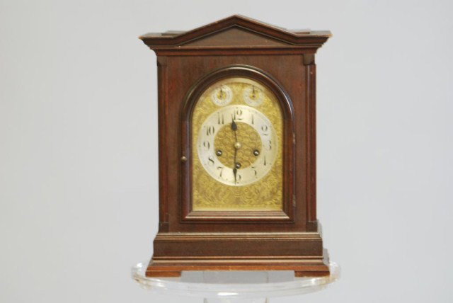 GEORGIAN STYLE MANTEL CLOCK: Mahogany case with German works and pendulum, but no key, 17"h x 12"w x 8"d. In good condition.