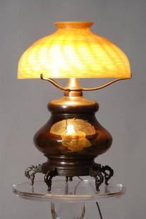 L.C.T. TIFFANY ART GLASS LAMP: Rook wood base and gold art glass shade (minor chip on the top rim) and floral Rook wood pottery base, 20"h, shade 13 1/2" diameter. In good condition.