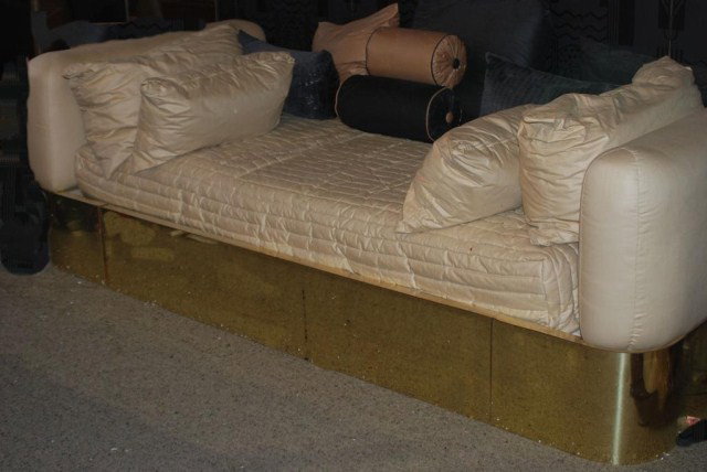 MODERN BRASS FRAME DAYBED: Beige upholstery with minor tear on one arm, 32"h x 102"w x 45"d. Normal wear for a piece of this age, otherwise in good "as found" condition.