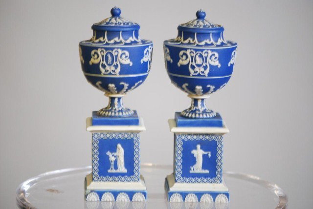 PR.WEDGWOOD JASPERWARE COVERED URNS: Medium blue with classical style white decoration, signed "Adams" on the bottoms, 9 1/2"h x 3"w x 3"d. One lid has old repair and minor chip on a corner.