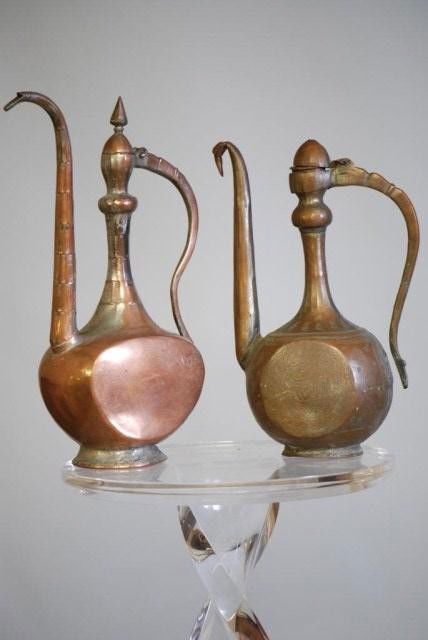 2-ANTIQUE MIDDLE EASTERN COPPER EWERS: 1-15 1/4"h x 8"w x 4 3/4"d, 1-13 1/2"h x 6 3/4"w x 5"d. Both with dents and damage.