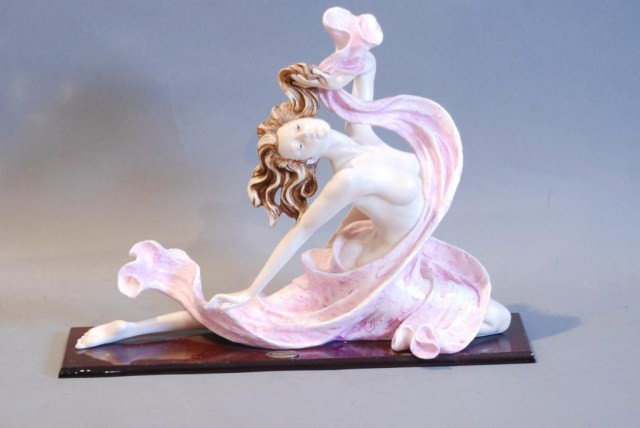 STATUE OF WOMAN IN PINK DRESS BY A. SANTINI: On wooden base, 12"h x 16"w x 4 1/2"d. In good condition.