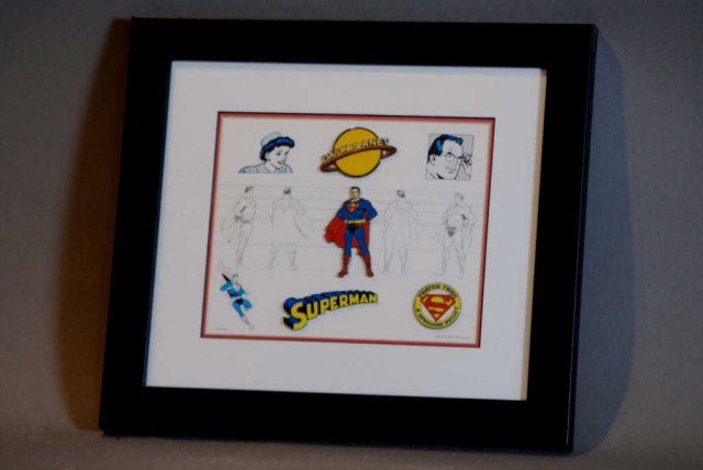 SUPERMAN W.B.COMEMORATIVE PIN&LITHOGRAPH SET: "Faster than a speeding bullet", daily planet and Superman logo, pins mounted and framed along with a lithograph, certificate of authenticity, authorized by Mark Taliani, #14 of 1500 from 2001, origin