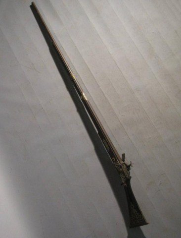 ANTIQUE MIDDLE EASTERN LONG RIFLE: Hardwood stock with ornate metal overlays, 67"L. In good "as found" condition.