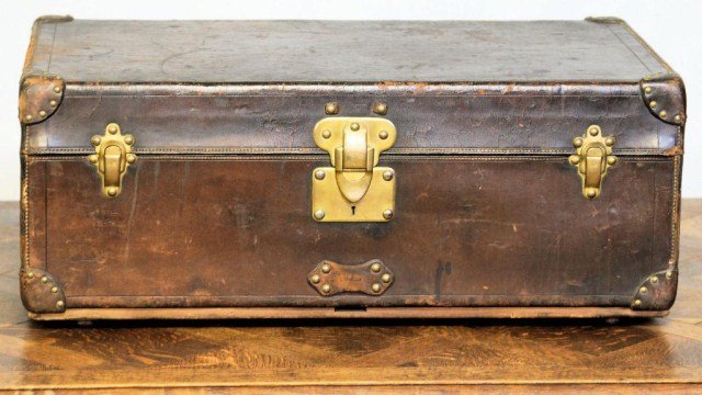 LOUIS VUITTON STEAMER TRUNK: Early Trunk with leather outer casing, brass latches, and hob nails, labeled on the interior rear wall, 12 1/2"H X 32 1/4"W X 20"D. Missing one handle, one handle detached, missing interior tray, othe