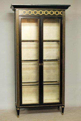 JANSEN STYLE VITRINE: Ebonized Vitrine with gilt trim exterior, silver leaf interior, with wood and glass inserted shelves, 90 1/2"H X 46 1/2"W X 20 1/4"D. In good condition.