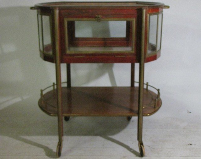 ROCKHAUSEN ROLLING LIQUOR CART: Rolling, glass enclosed cart with hinged drop-down doors and brass gallery. A handsome German piece from before World War II. Tight solid assembly, smooth rolling and hinged door action, lower brass g