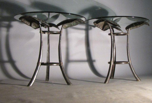 PAIR BRONZE LEAF FORM MODERN TABLES: Heavy cast bronze table bases with matching beveled glass tops. Good detail to the leaves and 'tied' fauz rattan legs, 29"W X 26"H. Negligible wear - readily dismissed.