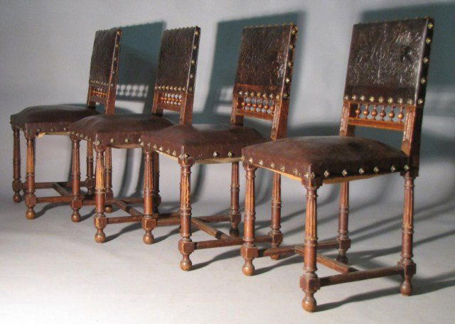 FOUR RENAISSANCE LEATHER SIDE CHAIRS: All four show obvious edge chafing, bumped corners & the odd missing brass stud. Despite any flaws, the stamped leather retains strong, high-relief detail; the frames remain tight, well-assembled & fu