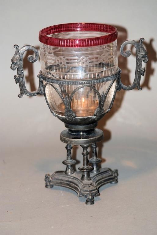 Victorian S.P. & Glass Chalice Cup: Victorian Silver Plate & Glass Chalice Cup. Griffin handled frame resting on swan feet. Etched clear glass insert with ruby colored rim. 9 1/2"H X 7"W X 4 1/2"D. Silver plate has wear, otherwise in go