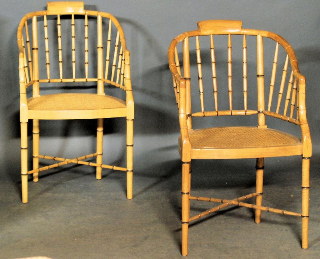 Baker Faux Bamboo Chairs: Pair of Baker Faux Bamboo Roundabout Chairs. Turned faux bamboo wooden frames with caned seats. 36"H X 21'W x 23'D. In good condition.