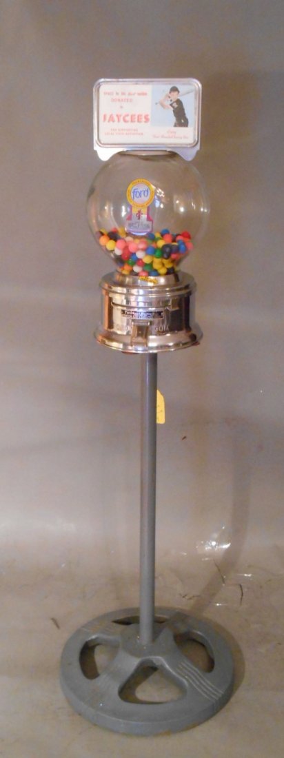 Ford Gumball Machine: Vintage 1950’s-1960’s Ford Gum and Machine Co. Inc 10 ¼” x 7” one cent gumball machine on original metal stand with key. Overall size is 42”.