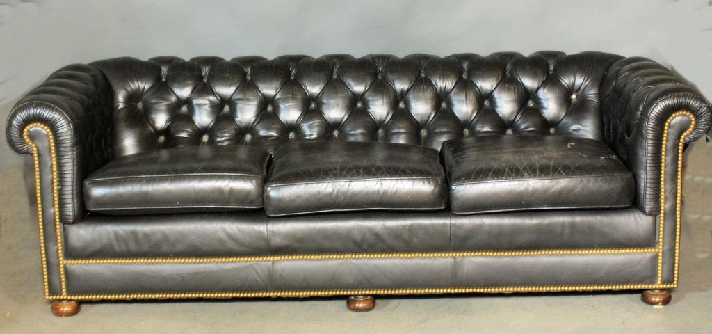 Chesterfield Style Leather Sofa: Black tufted leather with buttons on bun feet. 27"H X 87"W X 36"D. In good condition.