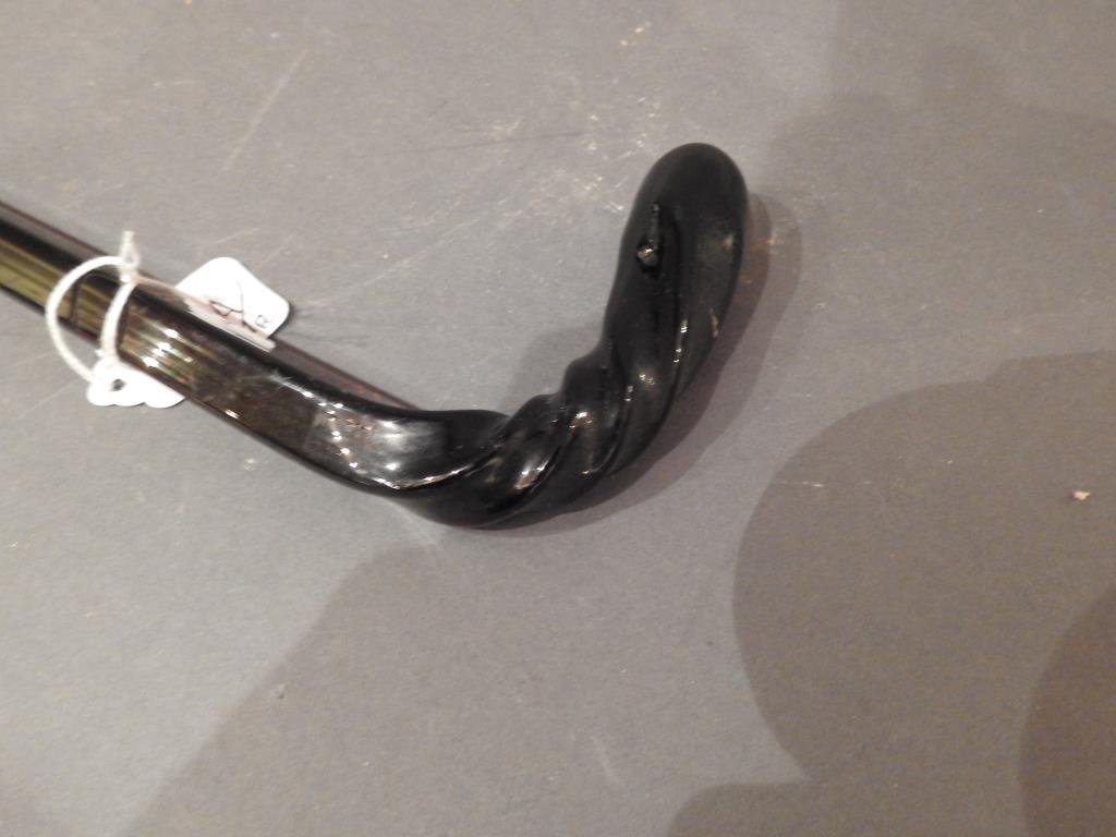 Antique Amber Glass Parade Cane: Antique amber glass 34"L Parade Cane with a swirl design. Condition: Roughness at end tip of cane.