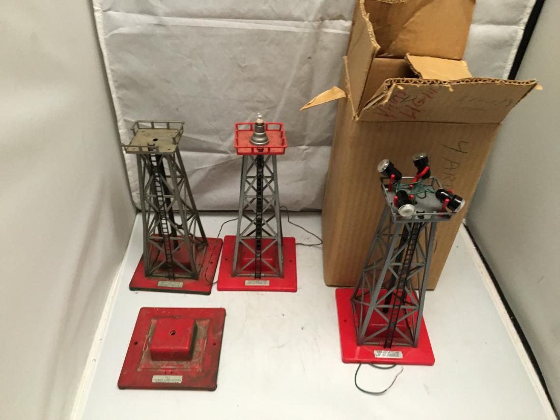 American Flyer Postwar S Gauge Light Towers: American Flyer Postwar S Gauge light towers. Yard floodlight in the original box, rotary beacon (missing the bulb cover), a light tower with no bulb mechanism and broken handrails, and the base for an
