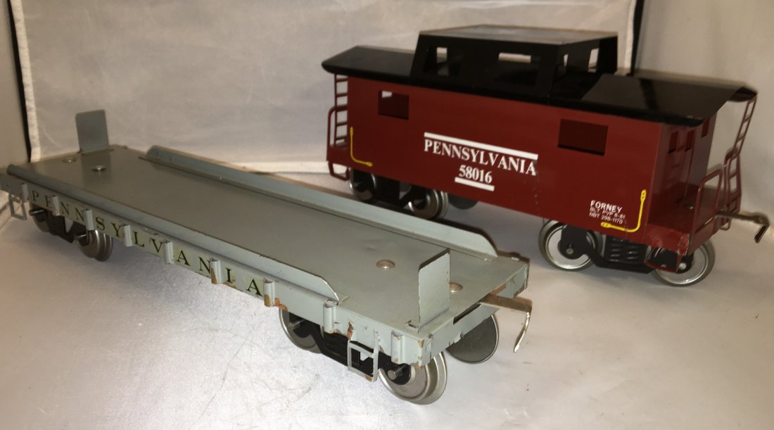 Forney PRR Standard Gauge Freight Cars: Two (2) Forney Pennsylvania standard gauge freight cars. There is a flat car and a caboose. Metal construction.
