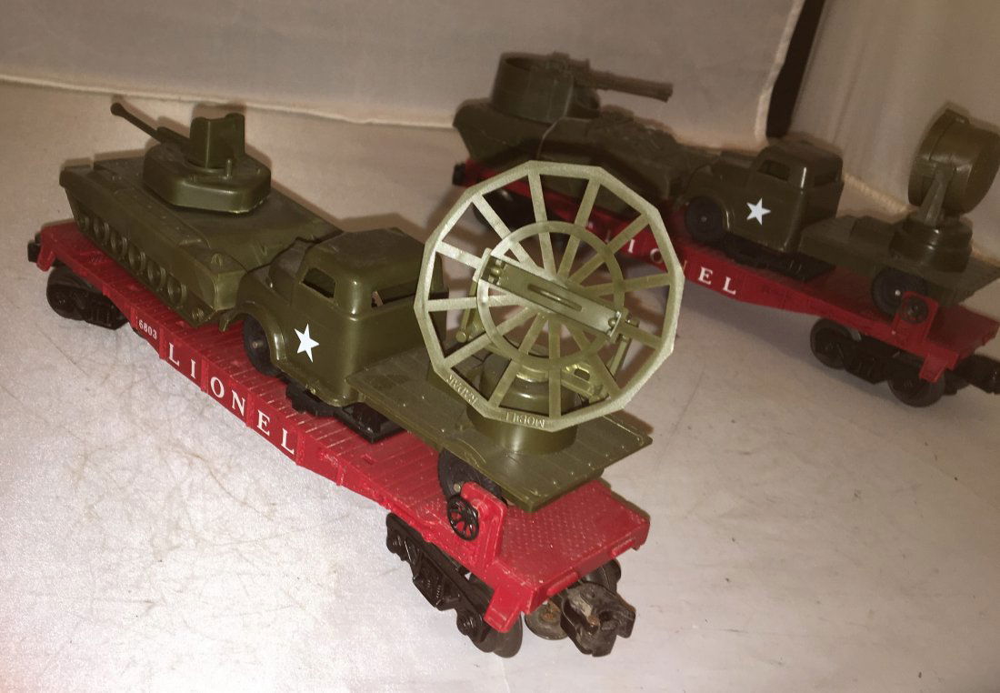 Lionel Postwar O Gauge Military Transport Cars: Lionel Postwar O gauge military transport cars. There is a 6803 with a tank (loose turret gun) and a radar truck load and a 6808 with a searchlight truck and armed vehicle load.