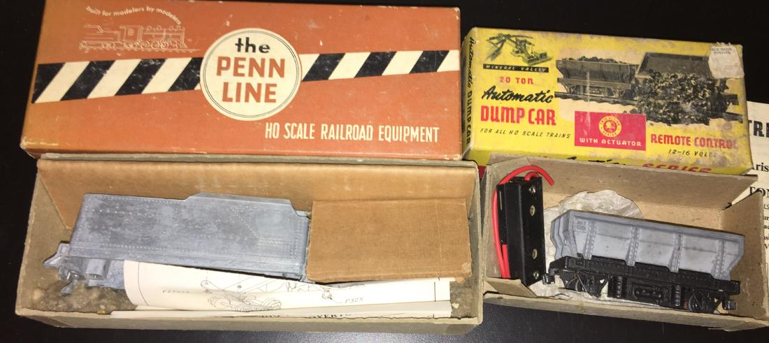 Vintage HO Scale Specialty Trains: Two (2) vintage HO scale specialty trains in the original boxes with paperwork. There is an Aristocraft Trix Action automatic dump car with activator and a Penn Line P-630 30 foot high side metal tend