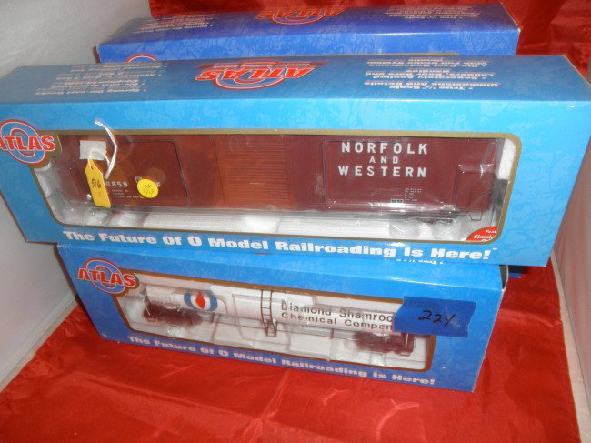 ATLAS O GAUGE LARGE FREIGHT CARS OB: Four (4) Atlas O gauge freight cars in the original boxes. Norfolk and Western box car, Diamond Shamrock tank car, Norfolk and Western double door box car, and Firestone hopper car.