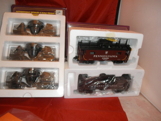 FIVE (5) MTH PREMIER O GAUGE FREIGHT CARS OB: Five (5) MTH Premier O gauge freight cars in the original boxes. Pennsylvania extended vision caboose, Pennsylvania N8 caboose, 3-car slag car set.