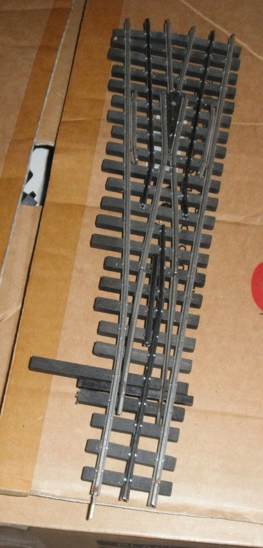 ROSS O GAUGE (3-RAIL) 054 LEFT HAND SWITCH: Ross O gauge (3-rail) 054 left hand switch: silver rails, wood-like ties, other very nice features, no box, very nice details, very nice color scheme.