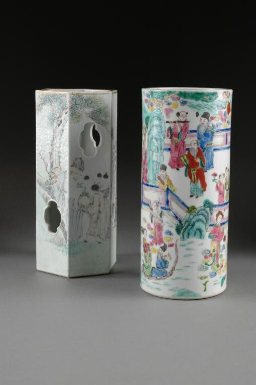 TWO CHINESE FAMILLE ROSE PORCELAIN HAT STAND,: LATE 19TH/EARLY 20TH CENTURY, one depicting figures at various pursuits set amidst a walled garden and enameled in bright colors, height: 11", the other hexagonal reticulated stand enameled with an el