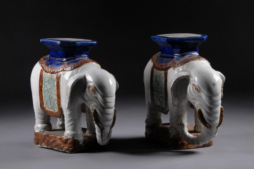 A PAIR OF CHINESE POLYCHROME GLAZED STONEWARE: ELEPHANT GARDEN STOOLS, 20TH CENTURY, each octagonal seat on a shaped stylized blanket stamped with four character marks and fretwork band suspending rectangular side panels of shallow relief foliage 