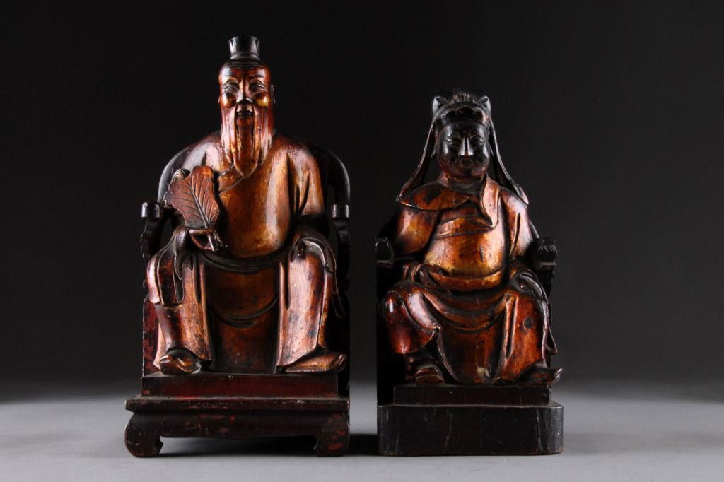 TWO ANTIQUE LACQUERED AND CARVED ALTAR FIGURES,: LATE 19TH/EARLY 20TH CENTURY, each modeled in a seated position in a traditional chair and wearing long flowing robes while holding a fan and another attribute beneath a smiling face.Heights: 13 3/4",