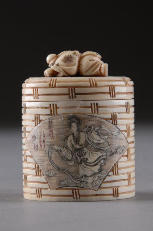 A JAPANESE CARVED IVORY BASKET FORM BOX WITH LID,: of oval shape with basket weave detailed sides centering fan form reserves enclosing a maiden deity in billowing robes amongst scrolling clouds reversing to a mountainous river scene with arched foot
