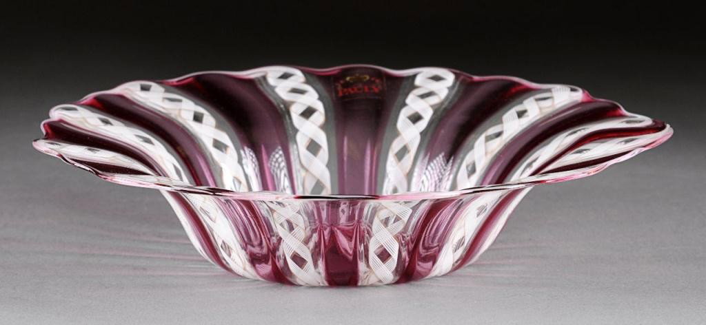A CRANBERRY RED AND LATTICCIO STRIPED CANDY DISH,: BY PAULY & C. COMPAGNIA DI VENEZIA E MURANO, LATE 20TH CENTURY, of circular form with waved rim and having vertical latticcio entwined with aventurine line alternating vertical cranberry red bands . E