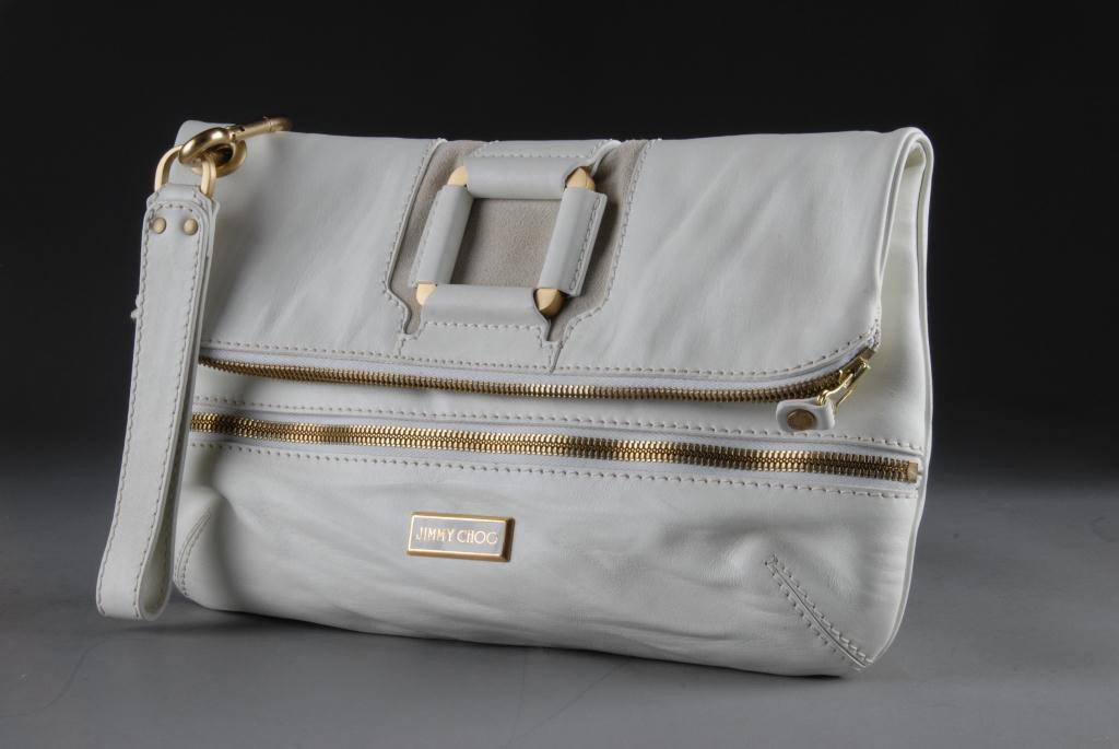 A JIMMY CHOO WHITE LEATHER MARIN OVERSIZED CLUTCH,: CIRCA 2000 With suede panel and gold tone metal square detail on a magnetically secured fold-over flap over a zippered front pocket, the main compartment with a zippered fastening and camel microsuede