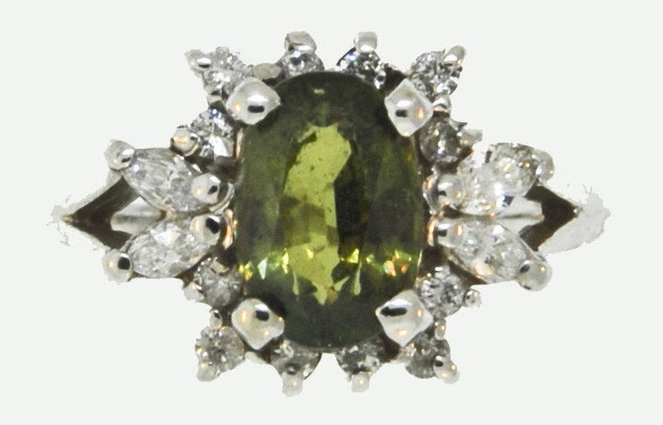 A 14K ANDALUSITE AND DIAMOND RING: In white gold with 1.50 Carat oval faceted Andalusite (often referred to as the poor man's alexandrite) and surrounded by 16 diamonds = .33 Carats, Color – K, Clarity – SI3. Size 8 ¼ (Sizeable). 