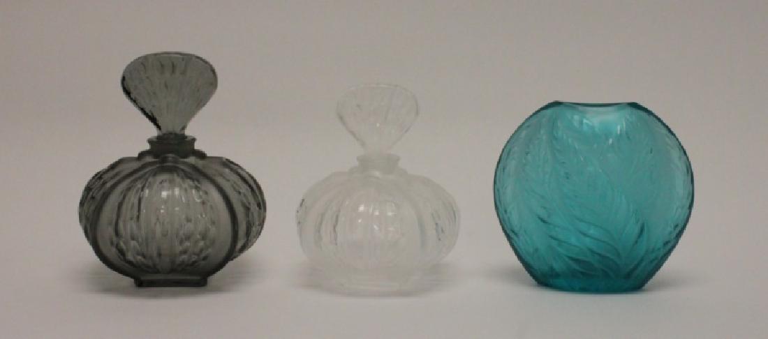 (3) Pcs. Lalique, France Crystal Perfumes & Vase: (3) Pieces of Lalique, France crystal includes (2) perfume decanters with stoppers and (1) small bud vase. All in excellent condition. Smoked or grey perfume measures 4.5"dia x 5.5" (with stopper). Cl