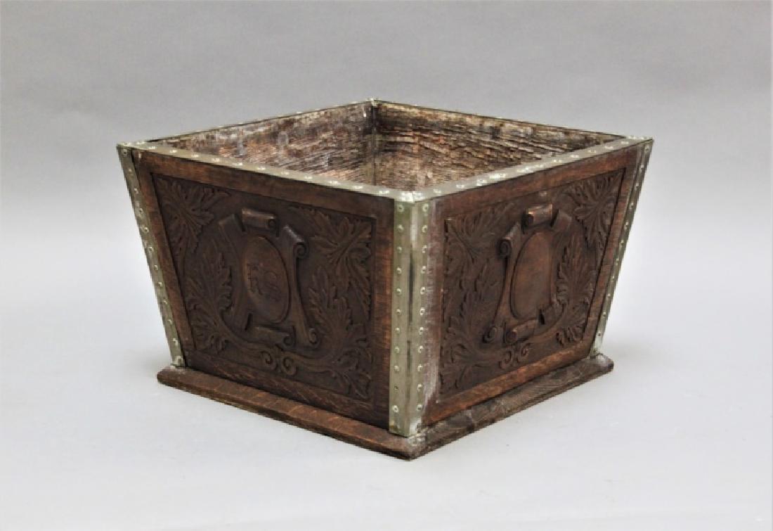 Arts & Crafts Brass & Oak Firewood / Coal Bucket: Antique Arts & Crafts era brass bound and carved oak firewood or coal bucket. Carved with a crest on all 4 sides. Excellent condition (some interior wear, see photos). Measures 18" x 18" x 12".